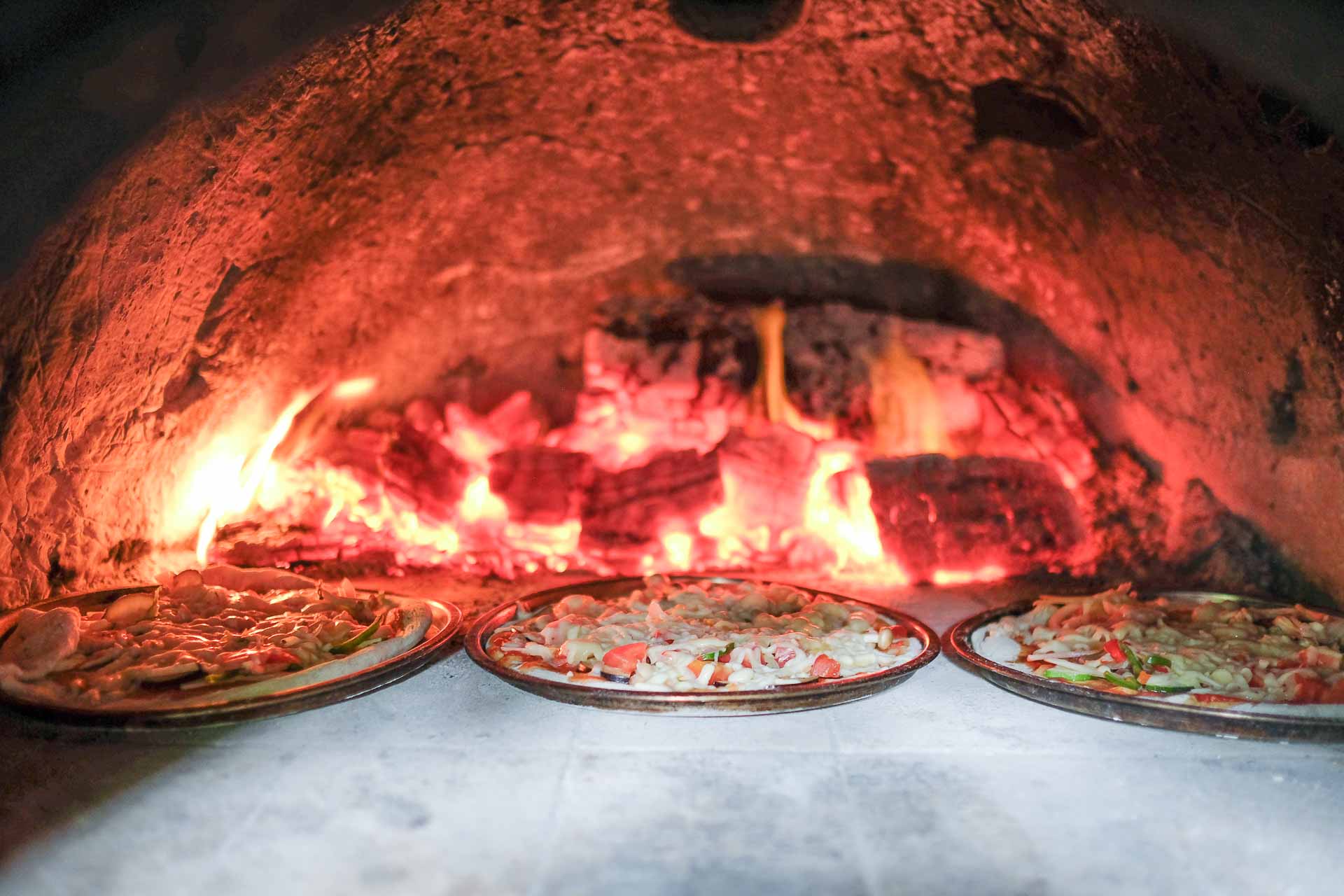 石窯に並ぶピザ